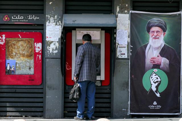 TOPSHOT - A man uses an automated teller machine (ATM) from Bank Mellat in Tehran on September 7, 2026. Iran's top negotiator threatened on September 6 of a more forceful response to any further US attacks after Tehran targeted American warships in their latest round of clashes. The exchanges of fire, which began with US raids last week, come amid a deadlock in the six-month war between the two foes. (Photo by AFP) / 