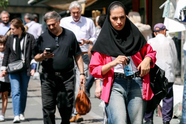 A woman walks along a street in Tehran on September 7, 2026. Iran's top negotiator threatened on September 6 of a more forceful response to any further US attacks after Tehran targeted American warships in their latest round of clashes. The exchanges of fire, which began with US raids last week, come amid a deadlock in the six-month war between the two foes. (Photo by AFP) / 