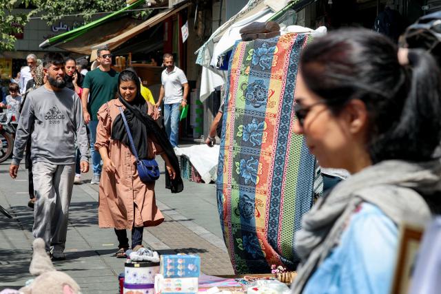 People walk along a market street in Tehran on September 7, 2026. Iran's top negotiator threatened on September 6 of a more forceful response to any further US attacks after Tehran targeted American warships in their latest round of clashes. The exchanges of fire, which began with US raids last week, come amid a deadlock in the six-month war between the two foes. (Photo by AFP) / 