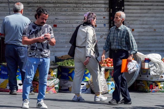 People walk along a market street in Tehran on September 7, 2026. Iran's top negotiator threatened on September 6 of a more forceful response to any further US attacks after Tehran targeted American warships in their latest round of clashes. The exchanges of fire, which began with US raids last week, come amid a deadlock in the six-month war between the two foes. (Photo by AFP) / 