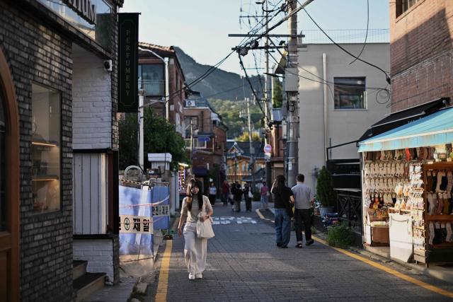 Pedestrians walk around Seoul's Jongno District on September 7, 2026. (Photo by Lillian SUWANRUMPHA / AFP)
