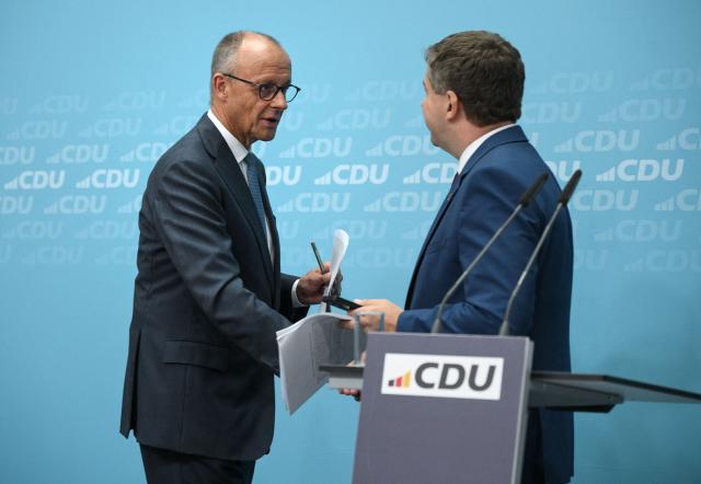 German Chancellor and leader of Germany's Christian Democratic Union (CDU) Friedrich Merz (L) and Saxony-Anhalt's State Premier Sven Schulze shake hands after a press conference following the party's leadership meeting in Berlin on September 7, 2026, one day after regional elections in the eastern federal state of Saxony-Anhalt. (Photo by RALF HIRSCHBERGER / AFP)