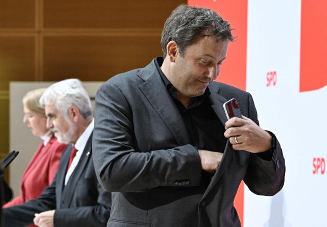 Chairman of the Germany's Social Democratic Party (SPD) and Vice-Chancellor Lars Klingbeil (R) gets up, as Armin Willingmann (C), top candidate of the social democratic SPD party for regional elections in Sachsen-Anhalt, and SPD co-leader Baerbel Bas (L) sit at the end of a press conference following an SPD leadership meeting in Berlin on September 7, 2026, one day after regional elections in the eastern federal state of Saxony-Anhalt. (Photo by Tobias SCHWARZ / AFP)