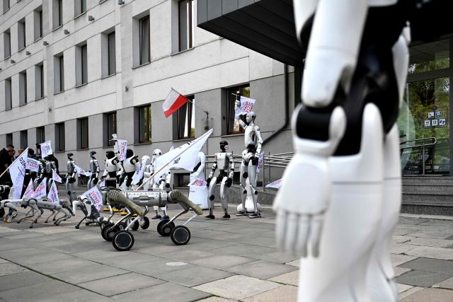 Humanoid and quadruped robots attend a demonstration calling for the regulation of artificial intelligence development in Warsaw on September 7, 2026. Waving flags, "chanting" slogans, and marching in circles -- around thirty robots took to the streets to raise awareness for AI regulation in front of the digital affairs ministry on September 7, 2026. (Photo by Sergei GAPON / AFP)