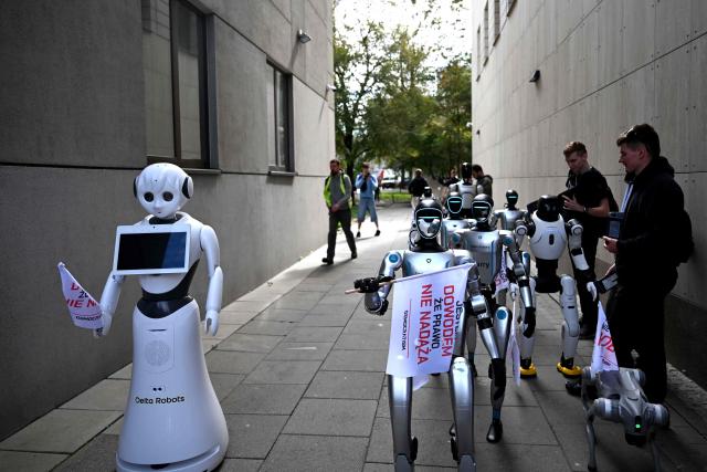 Humanoid robots gather before a demonstration calling for the regulation of artificial intelligence development in Warsaw on September 7, 2026. Waving flags, "chanting" slogans, and marching in circles -- around thirty robots took to the streets to raise awareness for AI regulation in front of the digital affairs ministry on September 7, 2026. (Photo by Sergei GAPON / AFP)