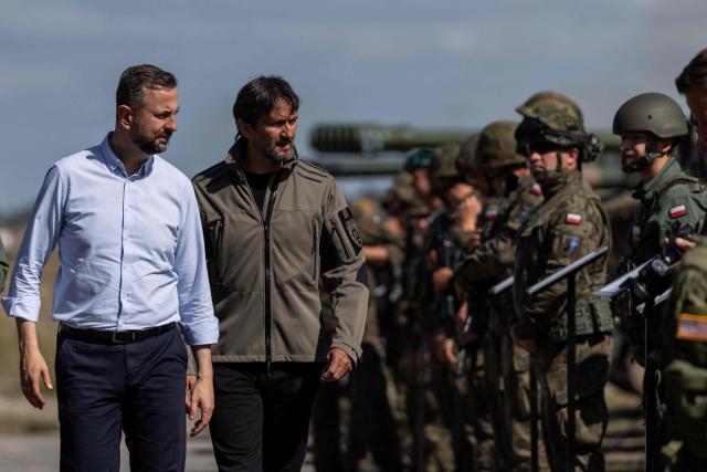 Poland's Deputy Prime Minister and Minister of Defence Wladyslaw Kosiniak-Kamysz (L) and Slovakia's Deputy Prime Minister and Minister of Defence Robert Kalinak (2-L) talk to Polish soldiers after a demonstration of Polish Army training at the military training ground in Nowa Deba, Poland on September 7, 2026, on the eve of the 34th International Defence Industry Exhibition. The 34th International Defence Industry Exhibition runs from September 8 to 11, 2026 in Kielce, Poland. (Photo by Wojtek RADWANSKI / AFP)