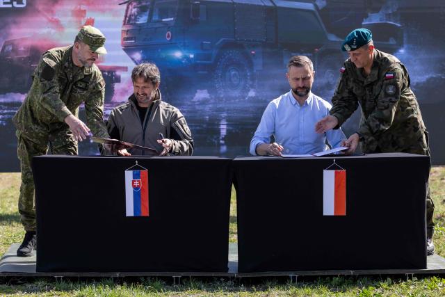 Poland's Deputy Prime Minister and Minister of Defence Wladyslaw Kosiniak-Kamysz (2nd R) and Slovakia's Deputy Prime Minister and Minister of Defence Robert Kalinak (2nd L) sign an agreement on military cooperation between Poland and Slovakia under the SAFE program after a demonstration of Polish Army training at the military training ground in Nowa Deba, Poland on September 7, 2026, on the eve of the 34th International Defence Industry Exhibition. The 34th International Defence Industry Exhibition runs from September 8 to 11, 2026 in Kielce, Poland. (Photo by Wojtek RADWANSKI / AFP)