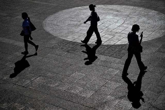 People are silhouetted near the banking district in Frankfurt am Main, western Germany, on September 7, 2026, as air temperatures reached 31 degrees Celsius. (Photo by Kirill KUDRYAVTSEV / AFP)