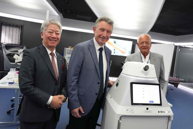 (LtoR) CEO of Kawasaki Heavy Industries Yasuhiko Hashimoto, President of the Grand Est region Franck Leroy and French doctor and founding director of the Research Institute against Digestive Cancer (IRCAD) Jacques Marescaux pose next to a robotic nurse at IRCAD, in Strasbourg, eastern France, on September 7, 2026. (Photo by Sébastien BOZON / AFP)