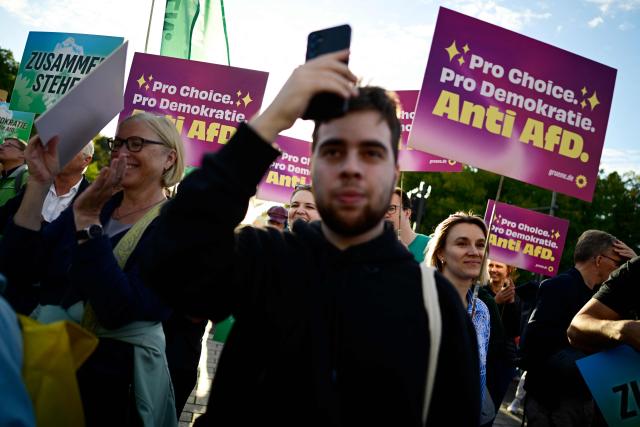 People protest and hold placards during a rally called by the organizations Campact and Fridays for Future named “Time to Act: Stop the AfD!" at the Brandenburg Gate in Berlin on September 7, 2026, one day after regional elections in the eastern federal state of Saxony-Anhalt. (Photo by John MACDOUGALL / AFP)