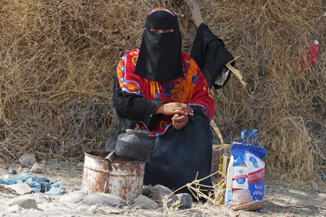 An internally displaced Yemeni woman who fled her home due to renewed clashes between Yemen's Saudi-backed government forces and the country's Houthi rebels, sits with her belongings after seeking shelter in Mocha, on the Red Sea coast of Yemen on September 7, 2026. (Photo by AFP)