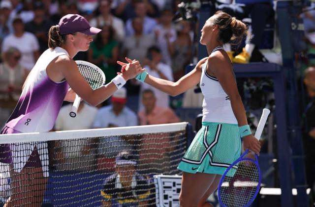 China's Qinwen Zheng (R) shakes hands with Poland's Iga Swiatek after defeating her in their women's singles round of 16 tennis match on day nine of the US Open tennis tournament at the USTA Billie Jean King National Tennis Center in New York on September 7, 2026. (Photo by KENA BETANCUR / AFP)