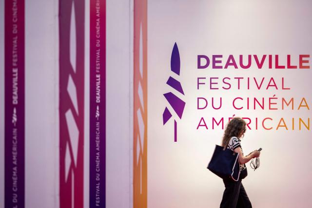 A guest walks past the Deauville american film festival logo displayed by the red carpet during the 52nd edition of the Deauville American film festival, in Deauville, northwestern France, on September 7, 2026. (Photo by Guillaume SALIGOT / AFP)