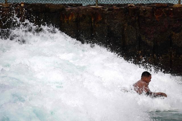 A bodyboarder rides through breaking surf at Electric Beach in Waianae, Hawaii, on September 7, 2026. A hurricane warning was issued September 7 for the westernmost Hawaiian islands of Kauai and Niihau as Category 3 Hurricane Lowell approached the US Pacific island chain, the National Hurricane Center (NHC) said. The core of Lowell was expected to pass just west of Niihau on the night of September 7 or early on September 8, the center said in its latest bulletin released at 8 am Hawaii time (1800GMT). (Photo by Michelle Bir / AFP)