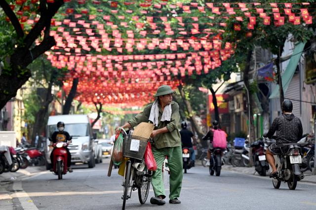 A street vendor pushes his bicycle along a street in Hanoi on September 8, 2026. (Photo by Nhac NGUYEN / AFP)