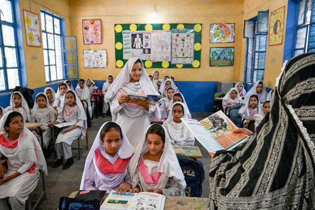 A teacher guides students inside a classroom at a school in Peshawar on September 8, 2026, marking the International Literacy Day. (Photo by Abdul MAJEED / AFP)