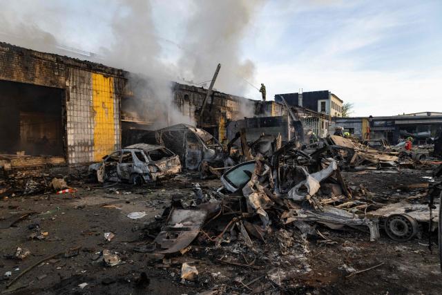 Smoke rises from a building near wrecked cars as firefighters battle a blaze following Russian missile strikes amid Russia's invasion of Ukraine, in Kyiv early on September 8, 2026. A wave of strong explosions rang out in Kyiv, AFP journalists said early on September 8, as Russia resumed strikes on the Ukrainian capital after a three-day halt. (Photo by Serhii Okunev / AFP)