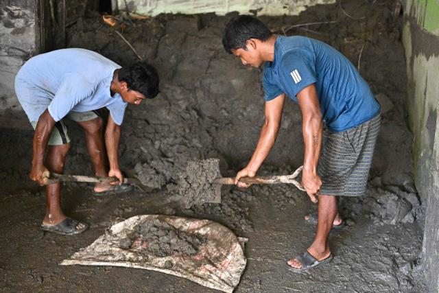 Men clear sludge from a house in the aftermath of flash floods at Devighat in Nepal's Nuwakot district on September 8, 2026. The August 26 glacial and mountain collapse on the China-Nepal border killed at least 1,399 people, with more than 5,500 missing, including around 800 foreigners. (Photo by Pedro PARDO / AFP)