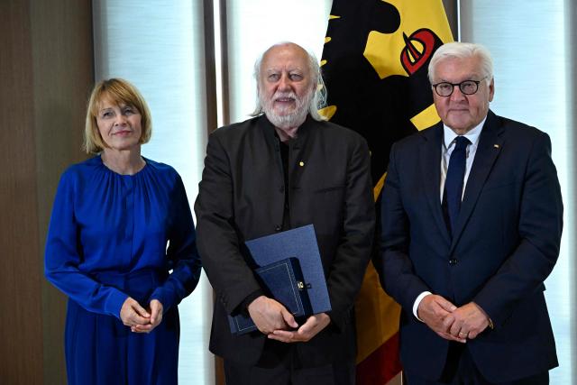 Hungarian writer and Literature Nobel Prize laureate László Krasznahorkai (C) poses with German President Frank-Walter Steinmeier (R) and the President's wife Elke Budenbender during the award ceremony for the Grand Cross of Merit with Star in Berlin, on September 8, 2026. (Photo by Tobias SCHWARZ / AFP)