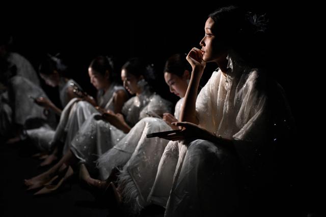Models wait backstage before presenting creations from the Guanju collection by Guan Yazheng during the China Fashion week in Beijing on September 8, 2026. (Photo by WANG Zhao / AFP)