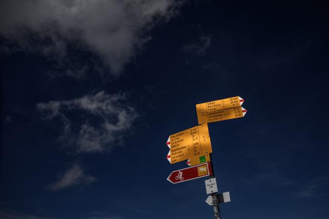 This photograph taken on September 1, 2026 shows Swiss Rando hiking trail signs near the Plaine Morte Glacier, above the resort of Crans-Montana in western Switzerland. The signs are part of Switzerland's extensive network of more than 65,000 kilometres of marked hiking trails maintained and promoted by Swiss Rando, helping visitors navigate the Alpine landscape. (Photo by Fabrice COFFRINI / AFP)