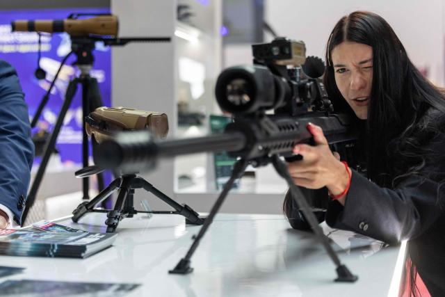 A woman tries out the scope of a rifle at one of the stands on the first day of the 34th International Defence Industry Exhibition in Kielce, Poland, on September 8, 2026. The 34th International Defence Industry Exhibition runs from September 8 to 11, 2026 in Kielce, Poland. (Photo by Wojtek RADWANSKI / AFP)
