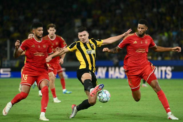 LASK's Czech midfielder #09 Krystof Denek (C) fights for the ball with AEK Athens' Hondurian midfielder #16 Kervin Arriaga (L) and LASK's Dutch defender #04 Xavier Mbuyamba during the UEFA Champions League - League phase, Matchday 1 - football match between AEK Athens and LASK at Agia Sophia Stadium in Athens on September 8, 2026. (Photo by Angelos Tzortzinis / AFP)