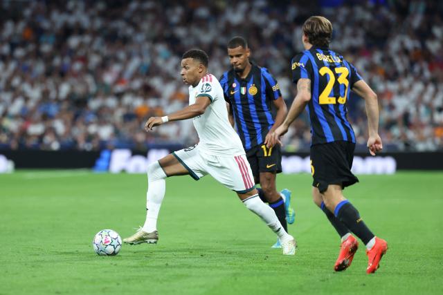 Real Madrid's French forward #10 Kylian Mbappe (L) runs with the ball past Inter Milan's Italian midfielder #23 Nicolo Barella (R) and Inter Milan's French midfielder #17 Andy Diouf during the UEFA Champions League first round day 1 football match between Real Madrid and Inter Milan at the Santiago Bernabeu stadium in Madrid on September 8, 2026. (Photo by Thomas COEX / AFP)