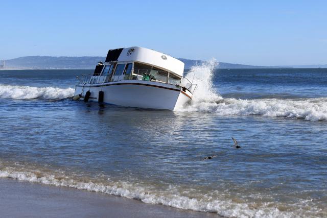 A grounded boat is seen after it has washed up on Playa Del Rey Beach, California, on September 8, 2026. Hurricane Marie stayed well offshore of Southern California during Labor Day weekend but its large swells produced dangerous surf and rip currents, with waves reaching around 10 feet in some areas. (Photo by David Swanson / AFP)