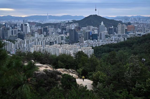 A hiker walks up Ansan mountain in Seoul on September 9, 2026. (Photo by Lillian SUWANRUMPHA / AFP)