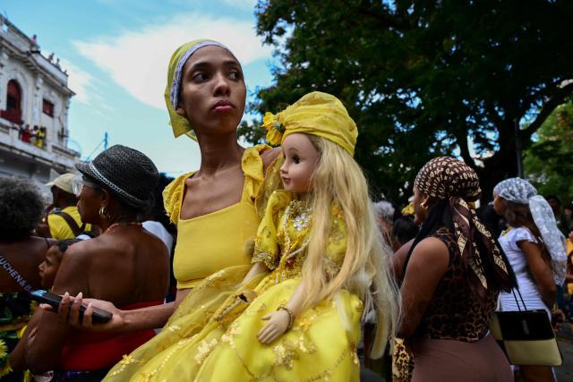 A follower of the Virgin of Charity, Oxun in the Yoruba religion, carries a doll as she takes part in a procession during the Oxun Day celebrations in Havana on September 8, 2026. (Photo by YAMIL LAGE / AFP)