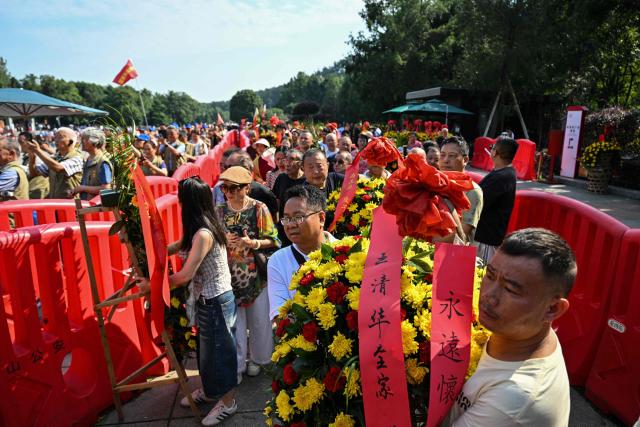 People arrive with floral arrangements to pay tribute to late Communist leader Mao Zedong at the Mao Zedong Bronze Statue Square in Shaoshan, China's central Hunan province on September 9, 2026, during the 50th anniversary of his death. (Photo by Hector RETAMAL / AFP)