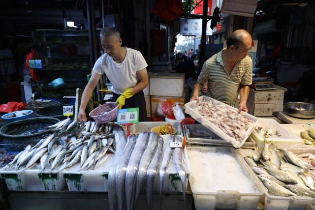 Two seafood vendors wait for customers at a market in Xiamen, in China’s eastern Fujian province on September 9, 2026. (Photo by CN-STR / AFP) / China OUT