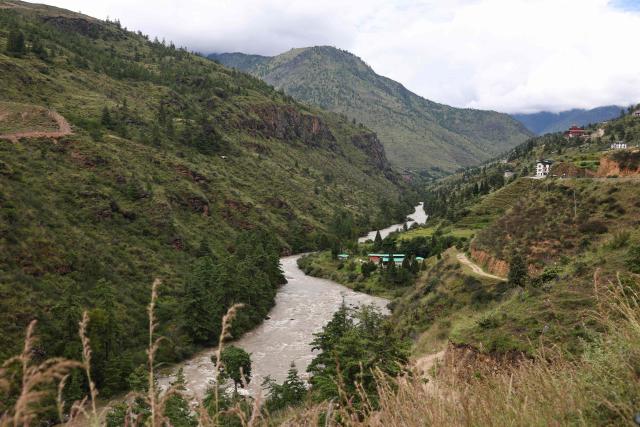 This photograph taken on September 3, 2026 shows the Wang Chuu river also known as Raidak river winding through a mountain valley near the Chuzom bridge in Paro, Bhutan. The glacial collapse that caused deadly floods on the Nepal-Tibet border late last month is a stark reminder of the dangers faced by Bhutan, which has over 600 glaciers nestled in the mountain ranges across its north. (Photo by Niharika KULKARNI / AFP)
