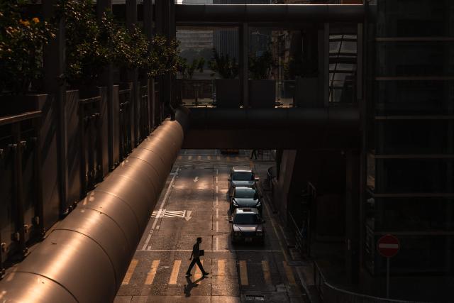 A man crosses a street in Hong Kong on September 8, 2026. (Photo by Dale DE LA REY / AFP)