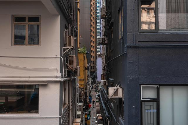A man walks between buildings in Hong Kong on September 8, 2026. (Photo by Dale DE LA REY / AFP)