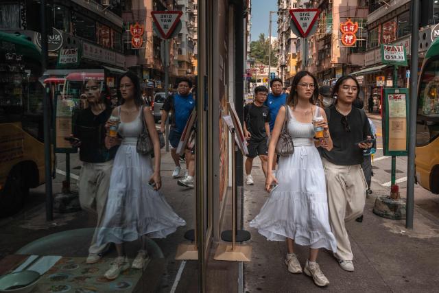 People walk along a street in Hong Kong on September 8, 2026. (Photo by Dale DE LA REY / AFP)