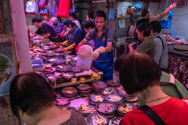 A fish vendor prepares a customer's order at a fresh food market in Hong Kong on September 9, 2026. (Photo by Dale DE LA REY / AFP)