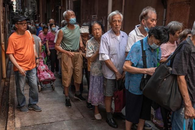 Elderly people wait in a queue to receive a coupon for free mooncakes, a baked item traditionally eaten during the Mid-Autumn Festival, from a charity in Hong Kong on September 9, 2026. (Photo by Dale DE LA REY / AFP)