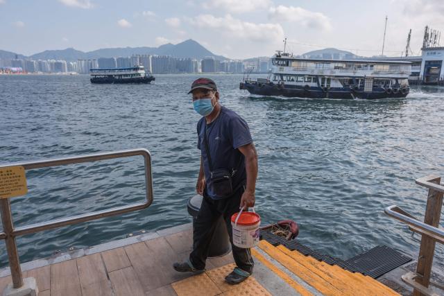 A man walks up stairs after returning to shore on a fishing boat at Victoria Harbour in Hong Kong on September 9, 2026. (Photo by Dale DE LA REY / AFP)