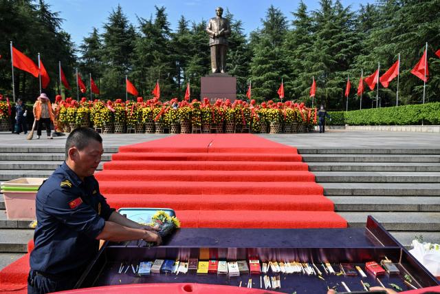 People pay tribute to late Communist leader Mao Zedong at the Mao Zedong Bronze Statue Square in Shaoshan, China's central Hunan province on September 9, 2026, during the 50th anniversary of his death. (Photo by Hector RETAMAL / AFP)
