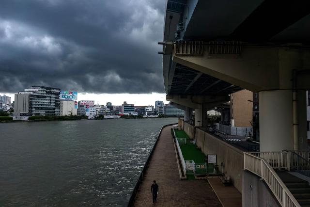 A man walks along the Sumida river in Tokyo on September 9, 2026. (Photo by Philip FONG / AFP)