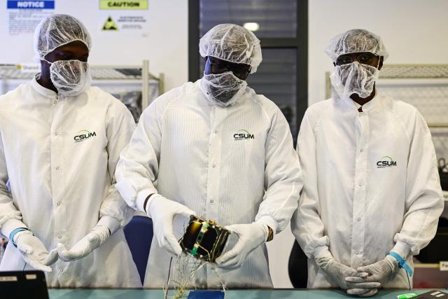 Senegalese Professor Gayane Faye (C), doctor in spatial remote sensing and coordinator of the development of Senegal's satellites, and his assistants check a part of the satellite Gaindesat-1B at the CSUM (Space University Center of Montpellier) in Montpellier, southern France, on September 4, 2026. Gaindesat-1B is designed to build on Senegal's first satellite, Gaindesat-1A, launched from California in 2024, and will collect environmental data and imagery to support natural resource management, territorial monitoring and climate observation. (Photo by Gabriel BOUYS / AFP)