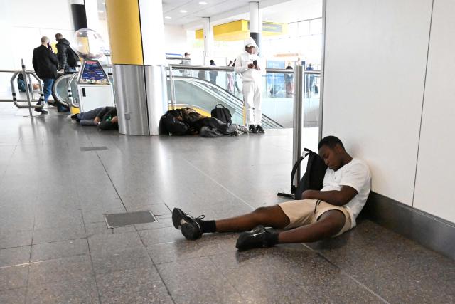 Travellers sit on the floor with their luggage at the North Terminal of London Gatwick airport near Crawley, southern England on September 9, 2026, following second day of major disruption due an issue affecting the NATS air traffic control systems. UK travellers faced more misery on September 9, with more than 150 flights scrapped across the country, as Britain's air traffic control service scrambled to recover from a technical glitch that sparked chaos. (Photo by JUSTIN TALLIS / AFP)