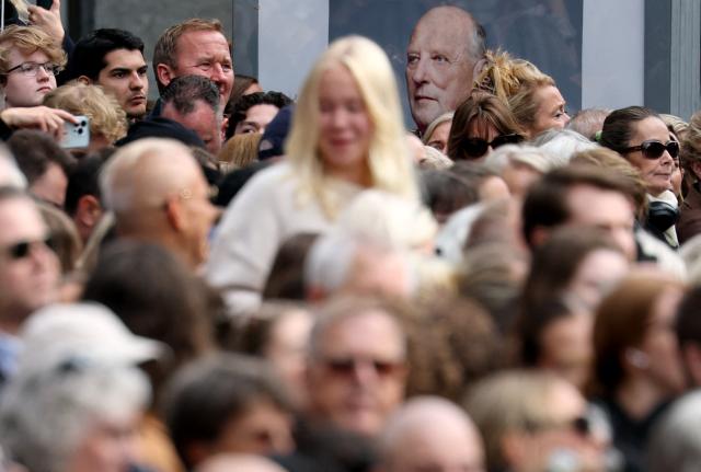 A portrait of Norway's late King Harald V is seen in the background as spectators gather in front of the church where will be taking place the funeral service for Norway's late King Harald V at the Oslo Cathedral in Oslo, Norway, on September 9, 2026. Harald, who died on August 28, 2026 at the age of 89, will be laid to rest in the crypt of the royal mausoleum of Akershus Castle, a medieval fortress overlooking Oslo Fjord, after a service at the Oslo Cathedral. (Photo by Odd ANDERSEN / AFP)