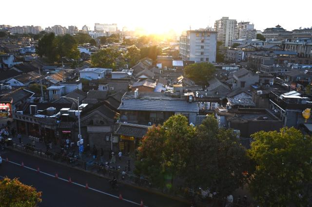 A residential area is pictured at sunset in Beijing on September 9, 2026. (Photo by GREG BAKER / AFP)