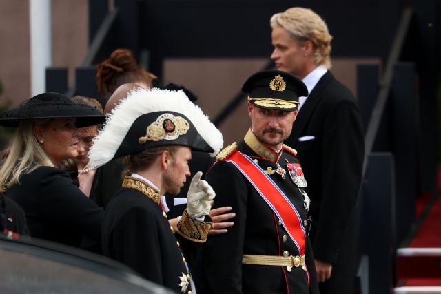 King Haakon VIII of Norway (2R) speaks with Lord Chamberlain and Chief of the Royal Court of Norway Olav Heian-Engdal (2L) next to Queen Mette-Marit of Norway (L) and her son Marius Borg Hoiby (background R) after the funeral service for late King Harald V of Norway before the casket is moved in a procession from Oslo Cathedral to Akershus Castle in Oslo, Norway, on September 9, 2026. (Photo by Odd ANDERSEN / AFP)