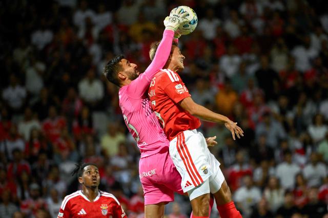 Moreirense's Portuguese goalkeeper #13 Andre Ferreira grabs the ball past Benfica's Portuguese midfielder #36 Joao Palhinha during the Portuguese League football match between Moreirense FC and SL Benfica at Comendador Joaquim de Almeida Freitas stadium in Moreira de Conegos on September 9, 2026. (Photo by Miguel RIOPA / AFP)