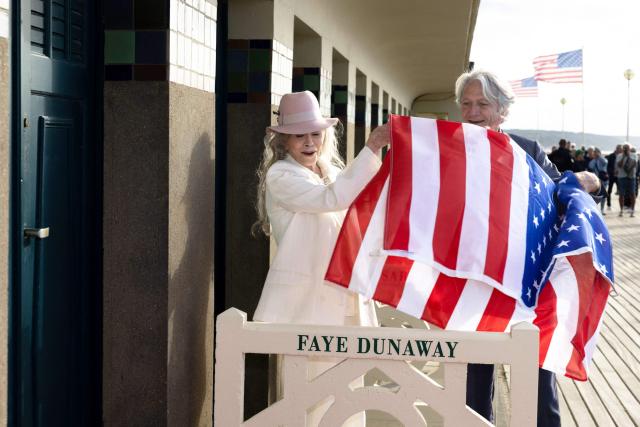 US actress Faye Dunaway lifts a US flags as she unveils a beach cabin dedicated to her during the 52nd edition of the Deauville American film festival, in Deauville, northwestern France on September 9, 2026. (Photo by Alain JOCARD / AFP)
