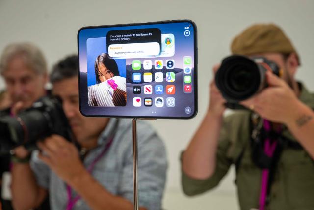 Journalists take photos of the new foldable iPhone Duo displayed during an Apple event at the Steve Jobs Theater in Apple Park in Cupertino, California, on September 9, 2026. Apple unveiled its long-awaited first foldable smartphone, the iPhone Duo, on Wednesday, at the company's first launch event since CEO John Ternus took the reins on September 1. Apple's first foldable comes seven years after Samsung pioneered the category, but the American tech giant is expected to take a sizable chunk of the market. (Photo by Karl Mondon / AFP)